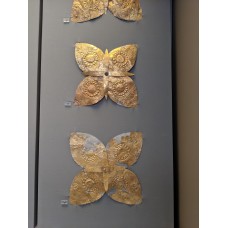 Gold butterfly-shaped ornaments featuring a central cross
